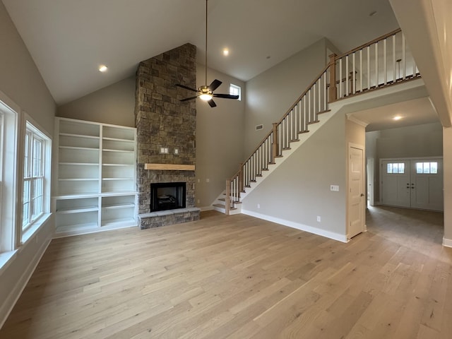 unfurnished living room featuring high vaulted ceiling, plenty of natural light, light wood-type flooring, and ceiling fan
