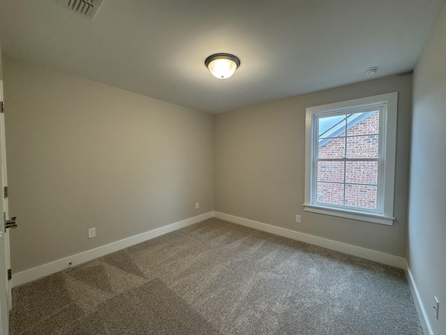 carpeted empty room featuring baseboards and visible vents