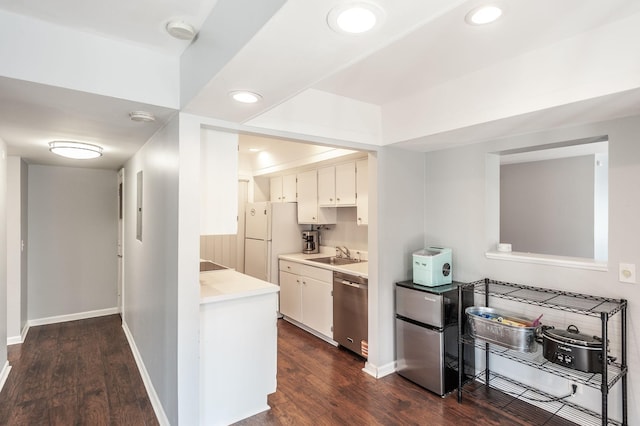 kitchen with a sink, appliances with stainless steel finishes, dark wood-type flooring, and light countertops