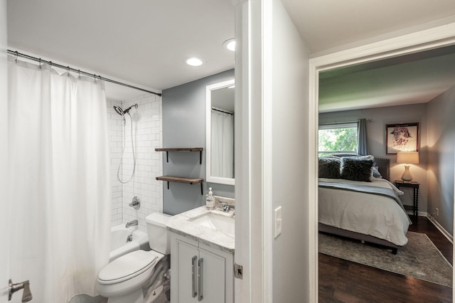 ensuite bathroom with connected bathroom, vanity, toilet, wood finished floors, and shower / tub combo