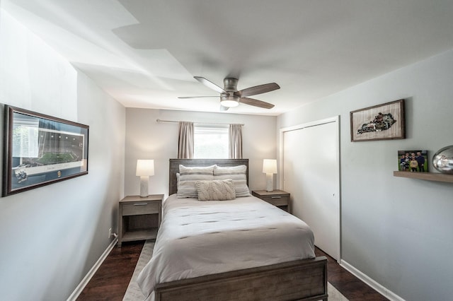 bedroom featuring baseboards, a ceiling fan, a closet, and dark wood-style flooring