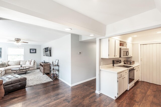 kitchen with white cabinets, electric range oven, light countertops, stainless steel microwave, and open floor plan