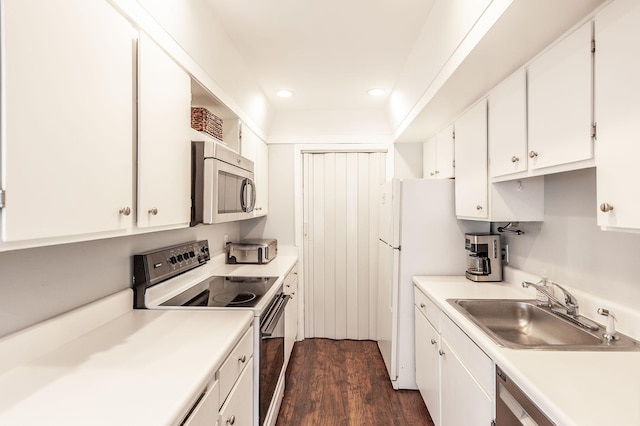 kitchen with dark wood-style flooring, a sink, stainless steel appliances, recessed lighting, and white cabinetry