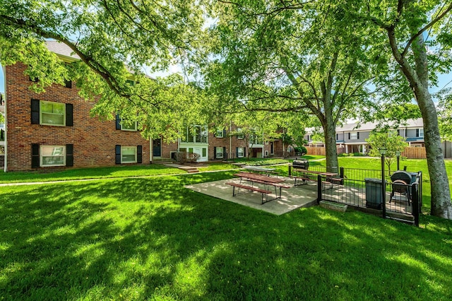 view of property's community with a yard and fence