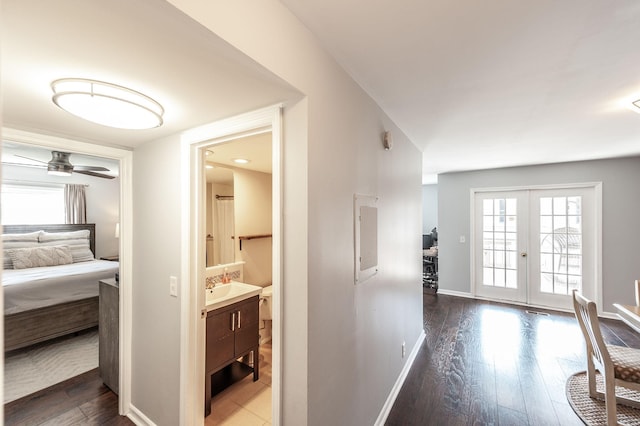corridor with baseboards, french doors, and wood finished floors