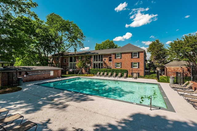 pool featuring fence and a patio