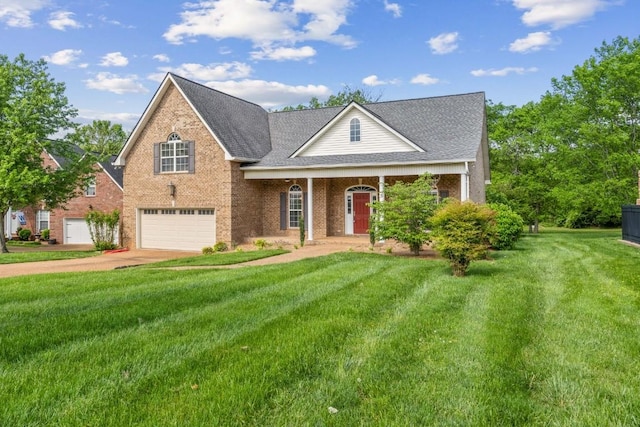 view of front facade with a front lawn, covered porch, brick siding, an attached garage, and driveway