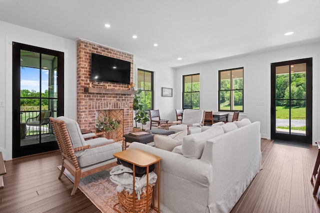 living room with recessed lighting, wood finished floors, and a fireplace