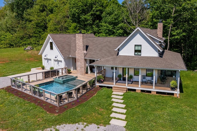 rear view of house featuring a lawn, roof with shingles, a pool with connected hot tub, and a chimney