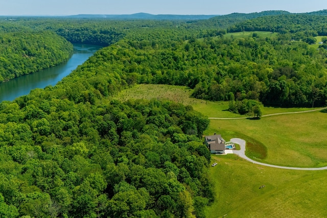 birds eye view of property with a water view and a wooded view