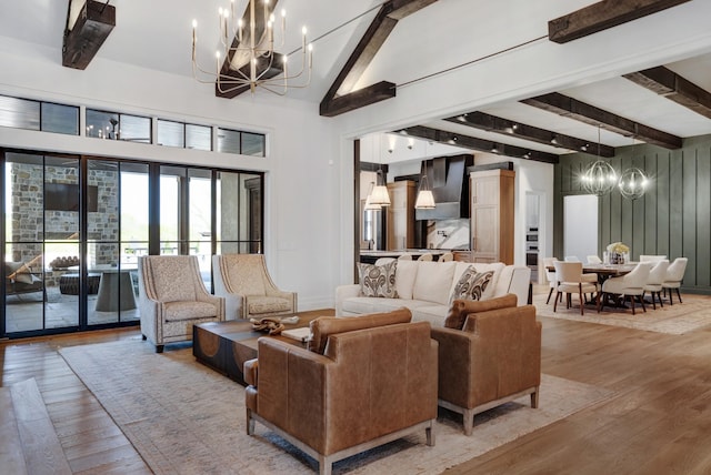 living area featuring an inviting chandelier, high vaulted ceiling, wood-type flooring, and beam ceiling