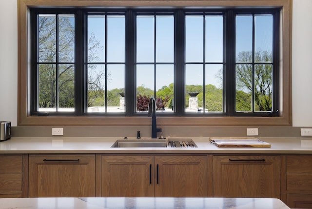kitchen featuring a sink, light countertops, and a healthy amount of sunlight