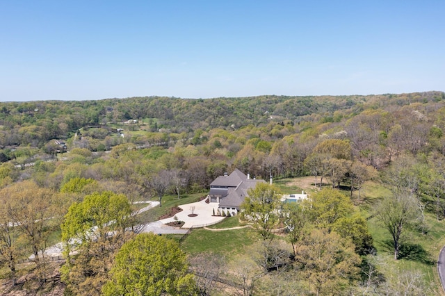 drone / aerial view featuring a wooded view