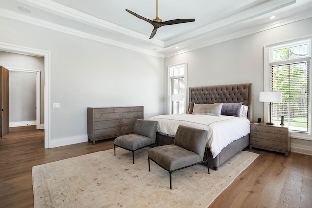 bedroom with baseboards, ornamental molding, wood finished floors, and multiple windows