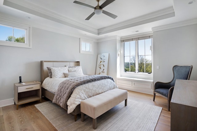 bedroom with visible vents, ornamental molding, wood finished floors, and a tray ceiling