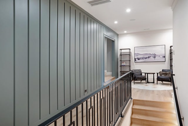 hallway with crown molding, light wood finished floors, recessed lighting, baseboards, and visible vents