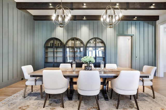 dining room featuring wood finished floors, a notable chandelier, and beamed ceiling