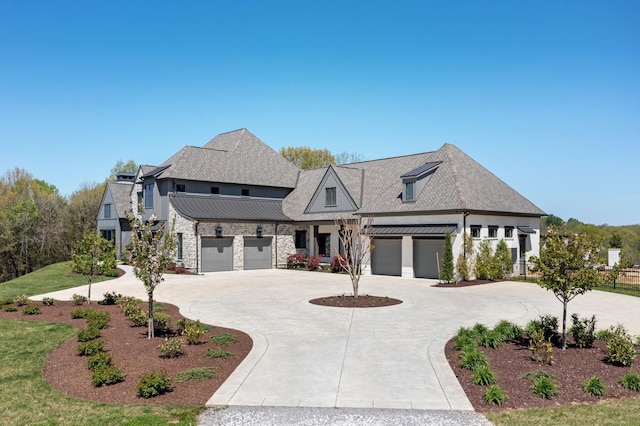 view of front facade with curved driveway, metal roof, stone siding, and a standing seam roof