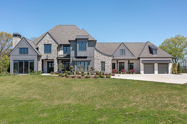 view of front facade featuring a front lawn, a standing seam roof, a chimney, and concrete driveway