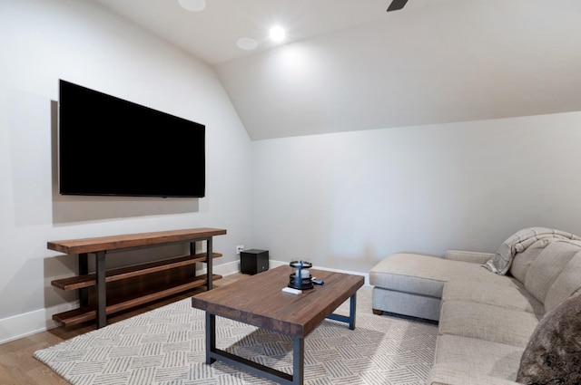 living room with baseboards, lofted ceiling, and wood finished floors