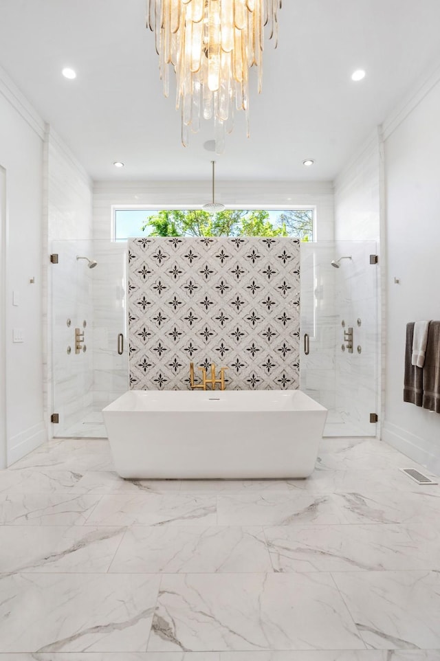 full bath featuring an inviting chandelier, a freestanding tub, baseboards, recessed lighting, and a shower stall