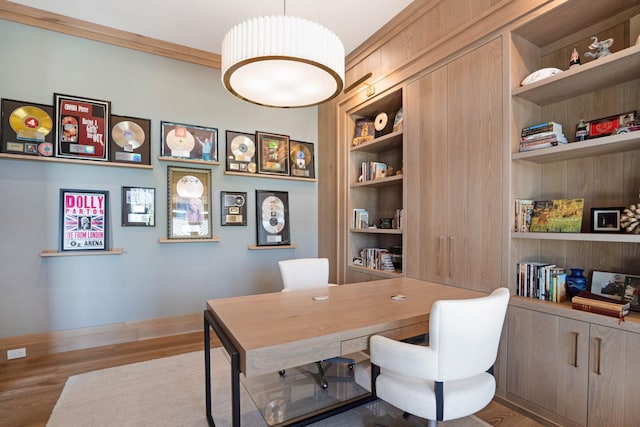 office space with built in features, baseboards, and wood finished floors