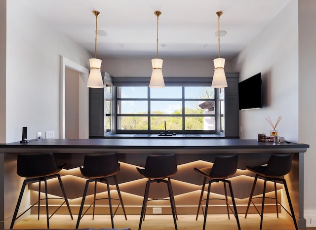 bar featuring pendant lighting and wood finished floors