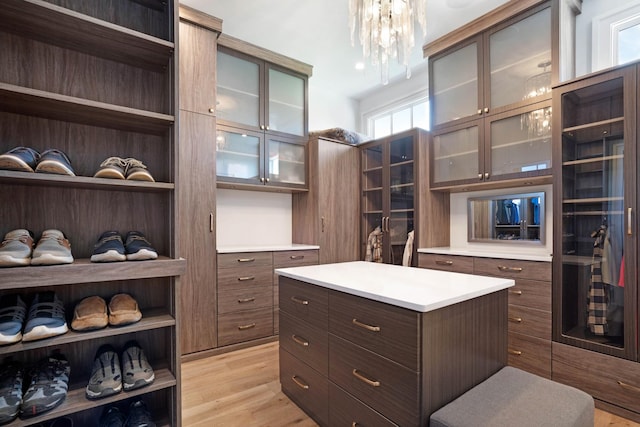 spacious closet featuring light wood-style floors and a chandelier