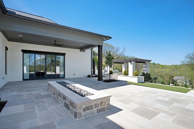 view of patio / terrace with a pergola, ceiling fan, and a fire pit