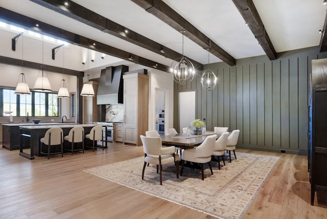 dining area with a chandelier, beam ceiling, and light wood-style flooring