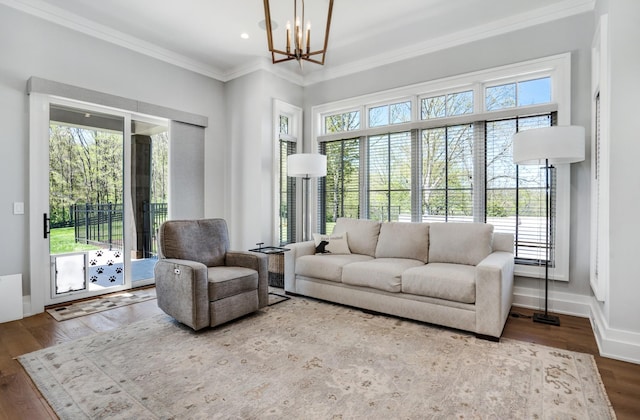 living area featuring crown molding, wood finished floors, a chandelier, and a wealth of natural light