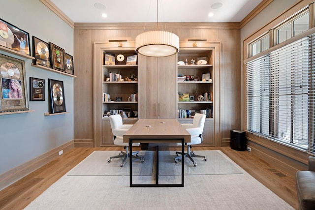 home office featuring built in shelves, baseboards, wood walls, and wood finished floors