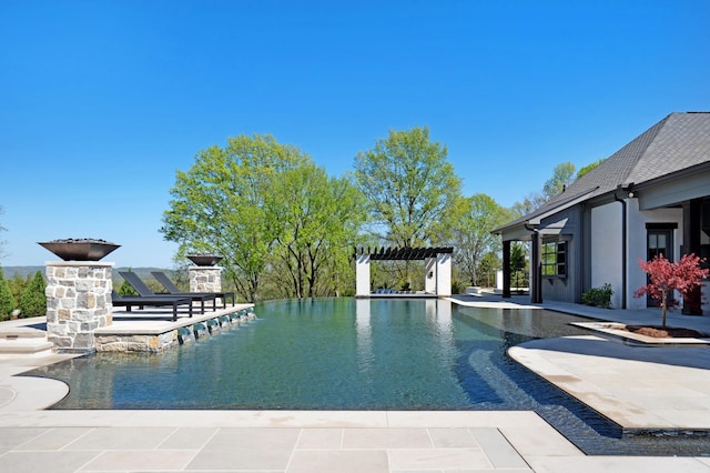 view of swimming pool with a patio, an infinity pool, and a pergola
