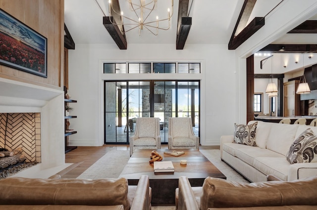 living area featuring baseboards, wood finished floors, a chandelier, and beamed ceiling