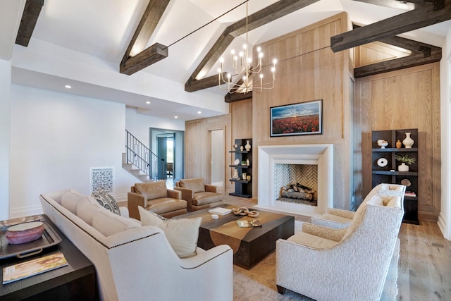 living area featuring a chandelier, beam ceiling, stairway, and light wood-type flooring