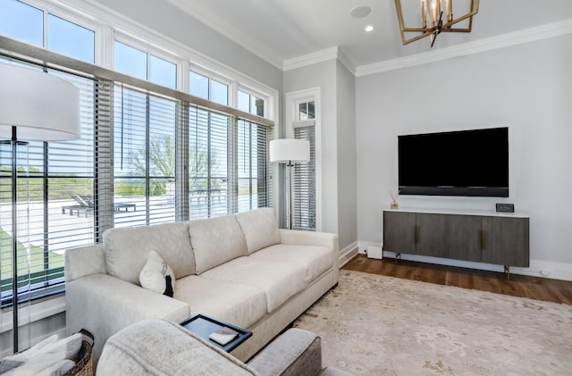 living area with crown molding, baseboards, an inviting chandelier, and wood finished floors