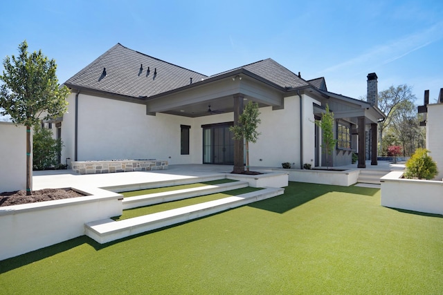 back of property featuring roof with shingles, stucco siding, a chimney, a patio area, and a ceiling fan