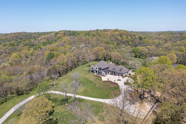 drone / aerial view featuring a wooded view
