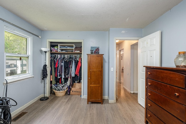 4051 New Highway 96 W, Franklin, TN 37064 - bedroom featuring light wood-type flooring, a closet, baseboards, and a textured ceiling