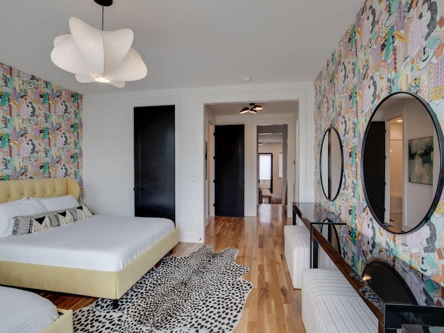 bedroom featuring baseboards, light wood-style flooring, and wallpapered walls