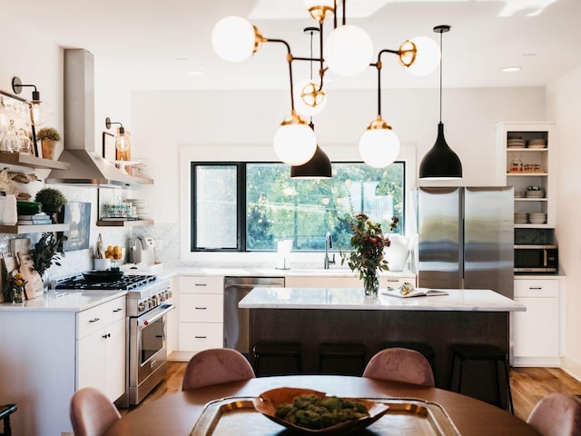 kitchen featuring open shelves, white cabinetry, light wood finished floors, stainless steel appliances, and wall chimney exhaust hood