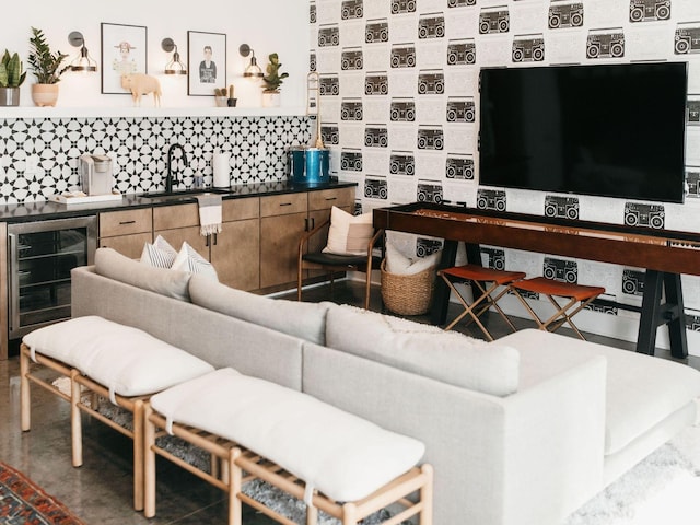 living room with wine cooler, indoor wet bar, and concrete flooring
