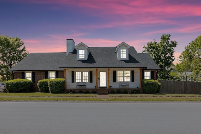 1077 Meandering Way, Franklin, TN 37067 - cape cod house with a lawn, fence, covered porch, and a chimney