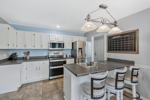 1077 Meandering Way, Franklin, TN 37067 - kitchen featuring stainless steel appliances, dark countertops, white cabinetry, and a sink