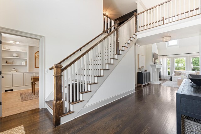 7314 Dug Hill Rd, Bon Aqua, TN 37025 - stairway featuring a fireplace, wood finished floors, a high ceiling, and built in shelves