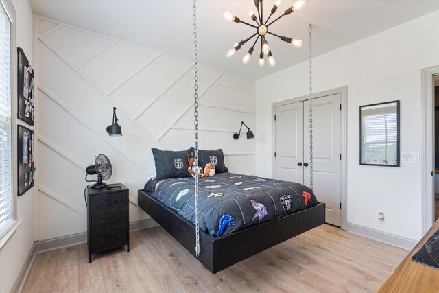 7314 Dug Hill Rd, Bon Aqua, TN 37025 - bedroom with a chandelier, light wood-style floors, and a closet