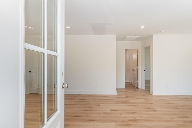 spare room featuring baseboards, recessed lighting, and light wood finished floors