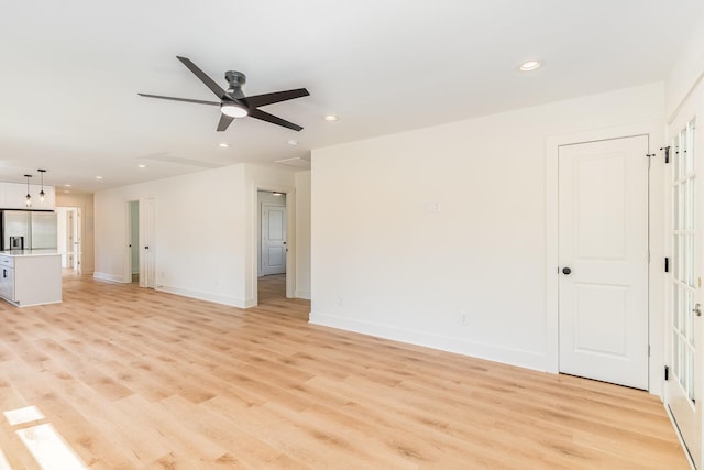 unfurnished living room with recessed lighting, baseboards, and light wood finished floors