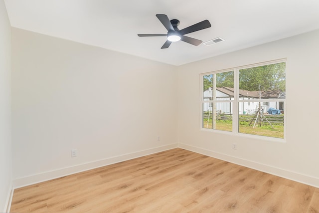 empty room with visible vents, light wood finished floors, ceiling fan, and baseboards