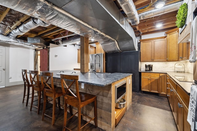 223 Kennett Rd, Old Hickory, TN 37138 - kitchen featuring appliances with stainless steel finishes, brown cabinets, a breakfast bar, and concrete floors